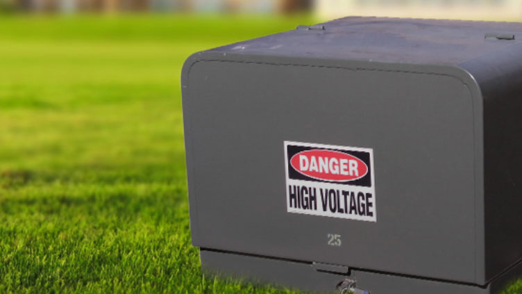 dark green electrical box with sticker that says danger, high voltage.
